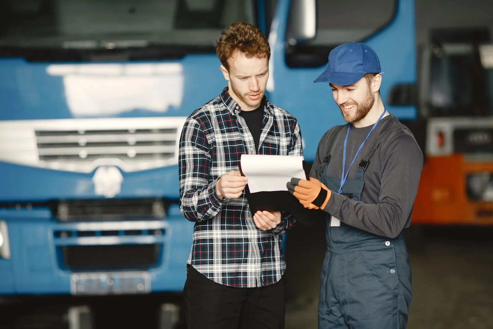 Zwei Männer besprechen Unterlagen vor einem Lkw